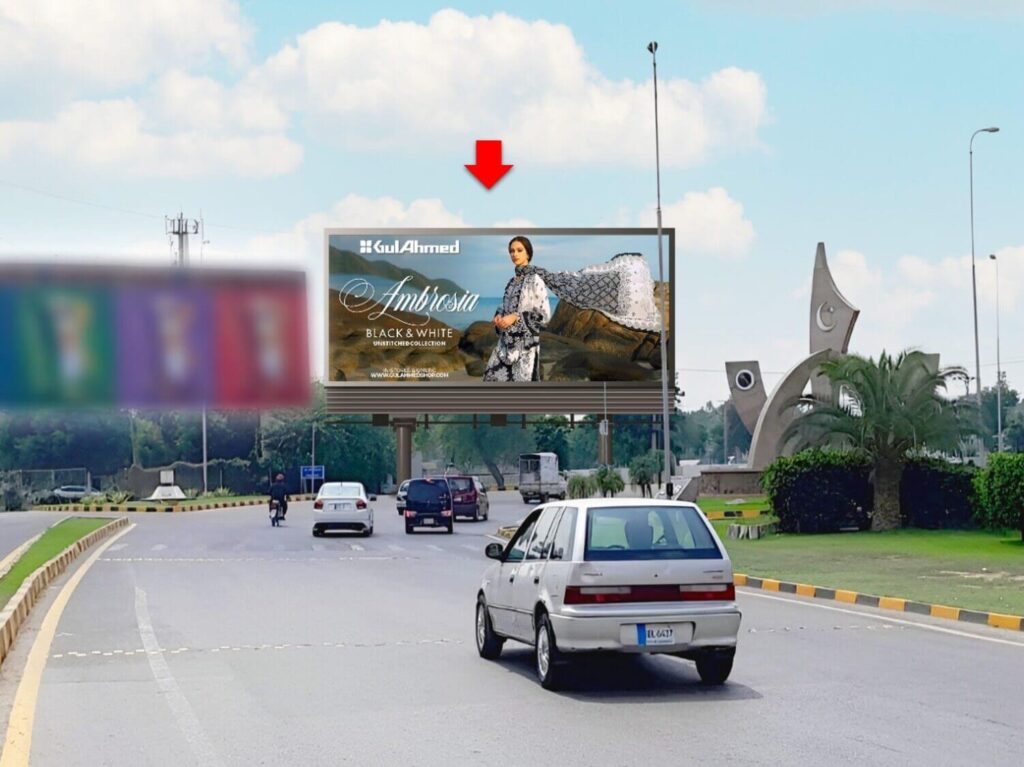 Billboard at Chowk Yateem Khana Lahore with busy traffic during the day